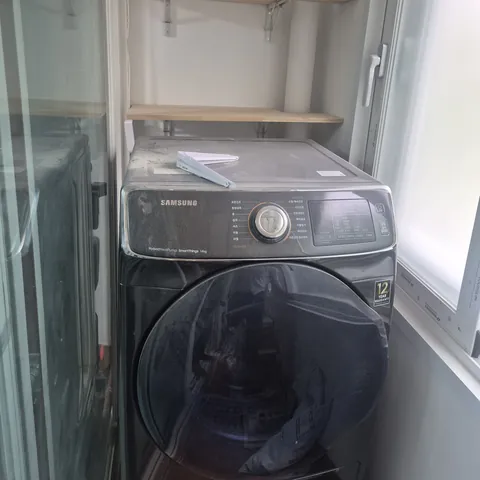 세탁기 앞면과 위쪽 선반이 보이는 세탁 공간