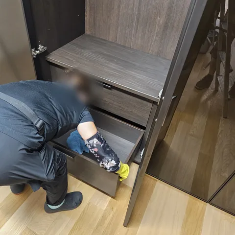 신축 주택 수납장 작업 중 현장 사진 - 수납장 서랍 안쪽을 닦는 작업 모습