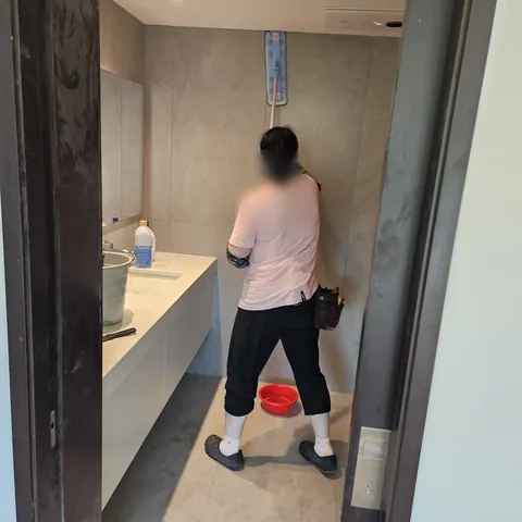 세면 공간 앞에서 벽을 닦는 작업 모습