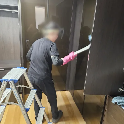 신축 주택 붙박이장 작업 중 현장 사진 - 붙박이장 문 표면을 닦는 작업 모습