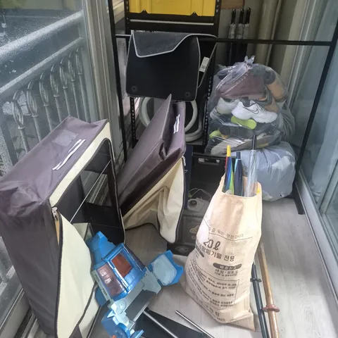 베란다 현장 상태 현장 사진 - 수납함과 짐, 포대가 쌓인 베란다